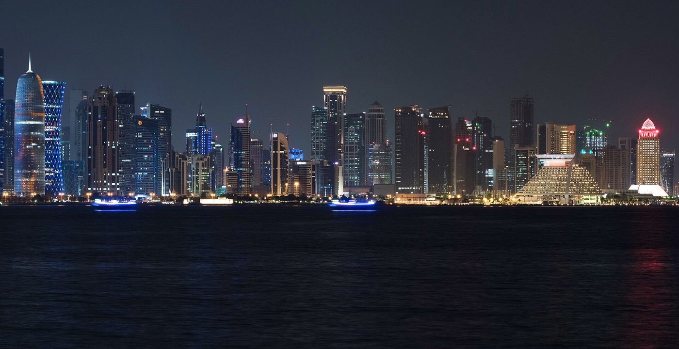 The West Bay skyline of Doha at night, reflected in the Gulf