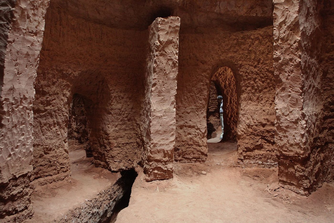 The inside of a working qanat tunnel, a low wet corridor with a stream along the floor